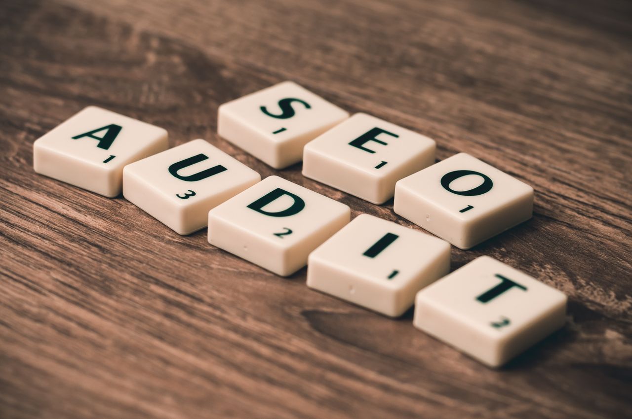 Wooden Scrabble tiles arranged to spell SEO Audit, representing digital marketing strategy.
